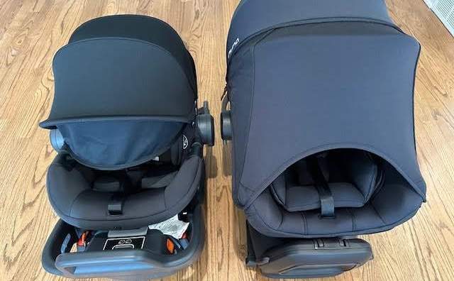 A side-by-side shot of a black UPPAbaby Aria next to a black Nuna Pipa Aire infant car seat. Each car seat has its canopy extended. The canopies cover almost the entire front of the seats.