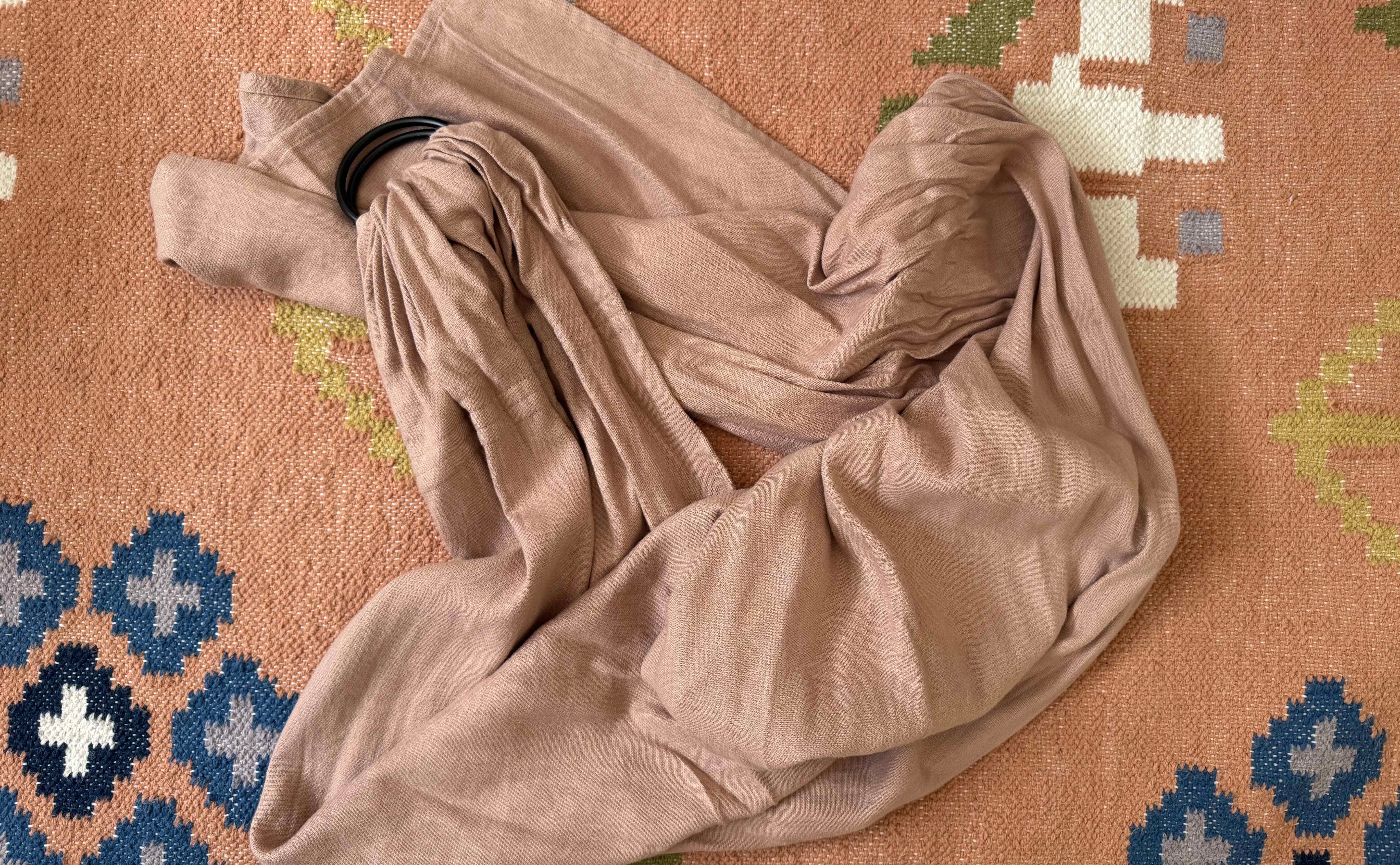 Wildbird Ring Sling on a rug background.