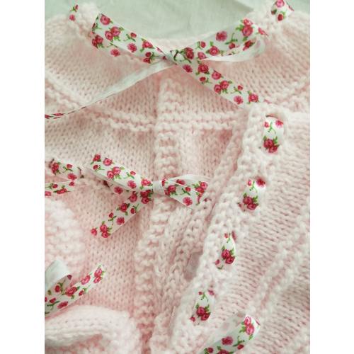 Conjunto de canastilla rosa con rosas sobre cinta blanca