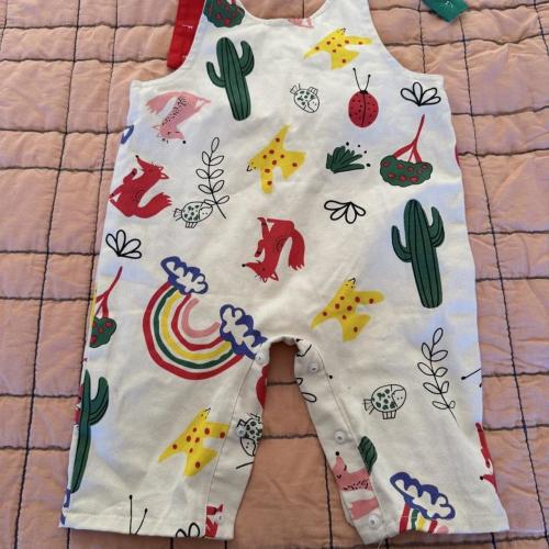 White baby overalls with colorful cartoon animals,...