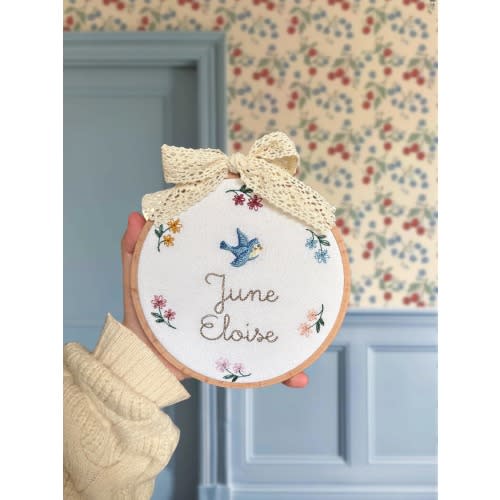 Embroidered plaque with baby’s name, a bluebird and a rainbow floral wreath | baby name announcement sign and nursery shelf decor