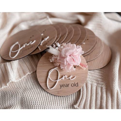 Wooden monthly milestone discs with dried flowers