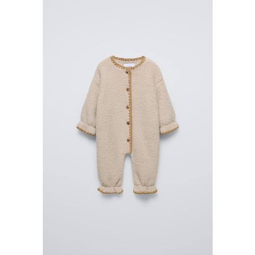 Bodysuit with round neck, long sleeves, and elastic cuffs. Front button closure. Contrasting color piping. - Beige | ZARA United States