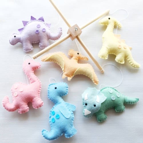 Pastel rainbow dinosaur mobile on a wooden frame