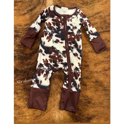 Cowprint baby sleeper has fold over hands and feet