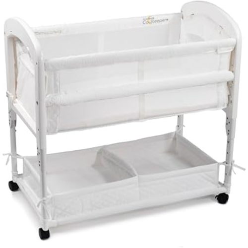 Arm’s Reach Cambria Co-Sleeper Bedside Bassinet Featuring Height-Adjustable Legs, Curved Wooden Ends, Breathable Mesh Sides with Pockets, and Large Lower Storage Basket, White