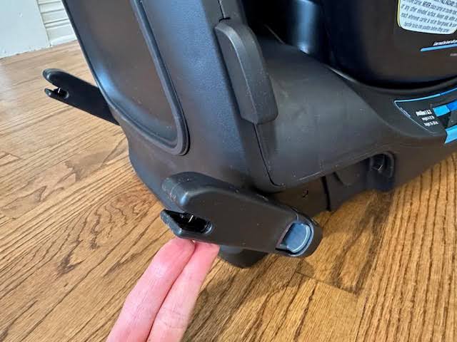 A zoomed in photo of the base of the Nuna Pipa Aire infant car seat's base, showing the integrated rigid LATCH connectors extending from the seat. The seat and the LATCH connectors are black.