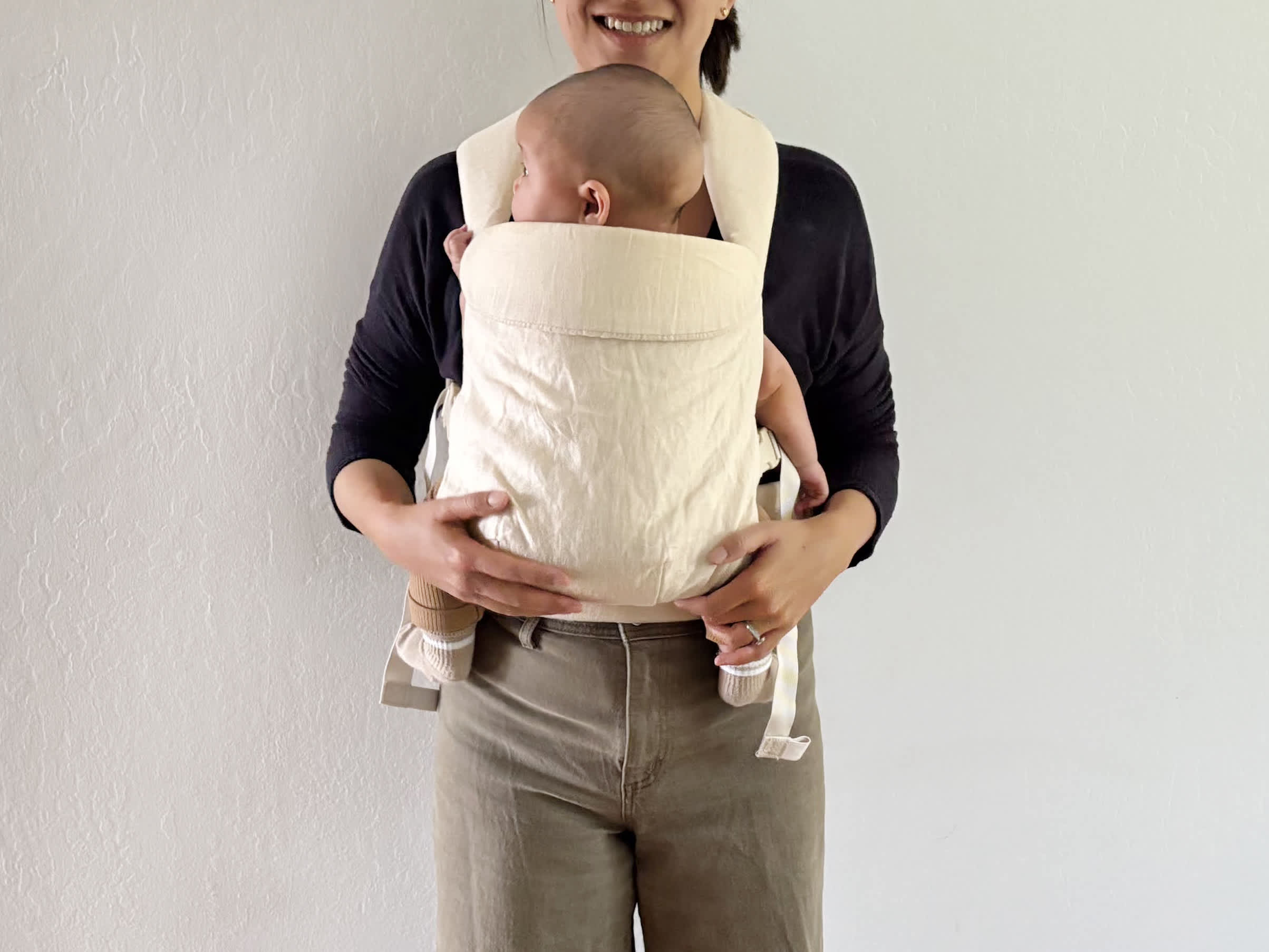 Parent wearing baby in the WildBird Aerial carrier.