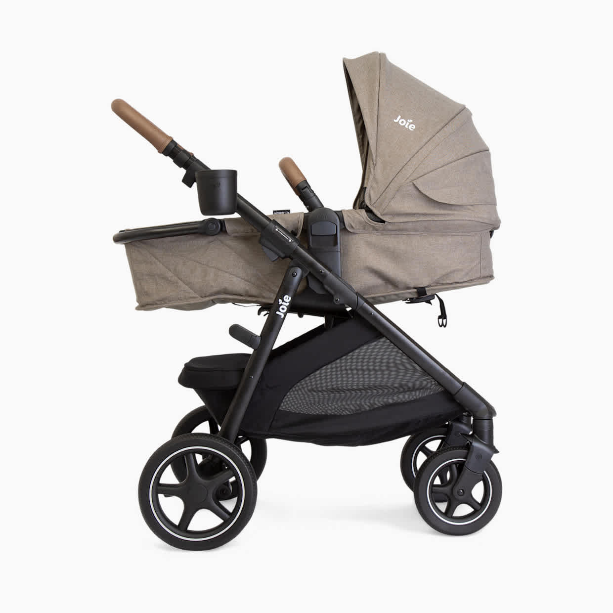Side view of the Joie Ginger LX stroller in beige in bassinet mode.