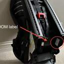 The back of an Evenflo Sonus 65 Convertible Car seat with a red arrow pointing to the seat's date of manufacture label, which includes important safety details including the date of manufacture, expiration date, model name and number. thumbnail.