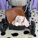 The storage basket of the UPPAbaby Vista V3 packed with a brown leather diaper bag and a stuffed pink rabbit. thumbnail.