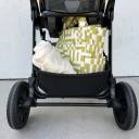 A close-up shot of the storage basket on the stroller of the Chicco Corso LE Modular Travel system packed with a green and white diaper bag, clothing and other small items. thumbnail.