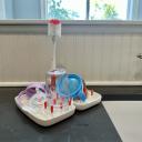 White Oxo On the Go drying rack filled with a straw cup, a snack container and accessories on top of a kitchen counter. thumbnail.