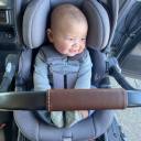 Top view of a young baby in a grey UPPAbaby Aria Infant Car Seat with the carry handle raised up. thumbnail.