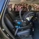 A side view of a black Clek Liing Infant Car Seat installed in a vehicle using the seat belt. thumbnail.
