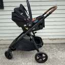 The Joie Ginger and Mint Latch Travel System in black against a beige background thumbnail.