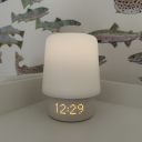 A Hatch Baby sound machine in white, with the night light on, on a white shelf thumbnail.