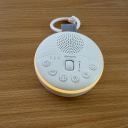 A flat lay of the Sprucely Travel Sound Machine in white with the night light illuminated. thumbnail.